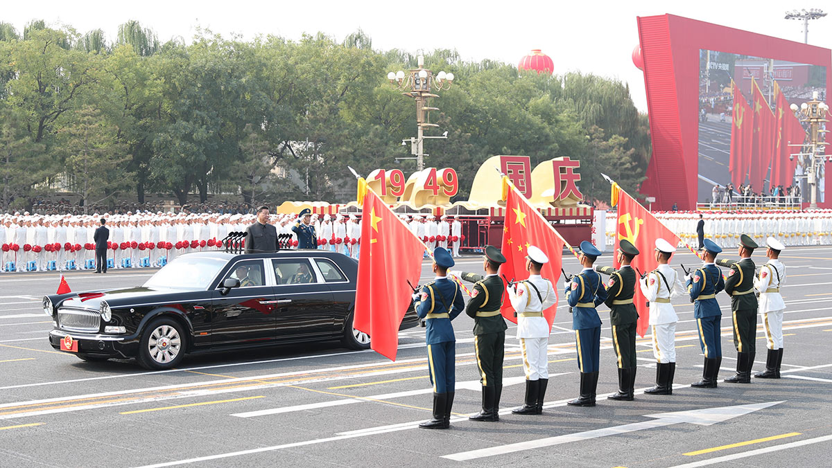 習近平驅(qū)車行進至黨旗、國旗、軍旗前，向旗幟行注目禮