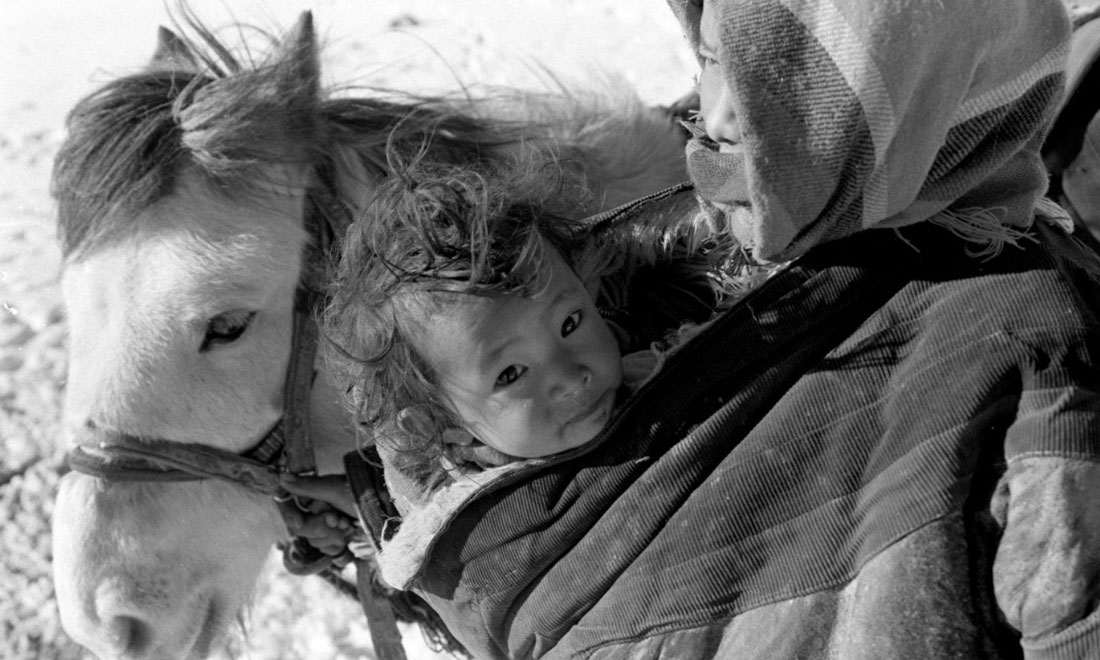 1990年3月，西藏當雄縣納木湖鄉(xiāng)三村女牧民斯卓不畏嚴寒，懷抱幼子，準備到遠處放牧。新華社記者覺果攝