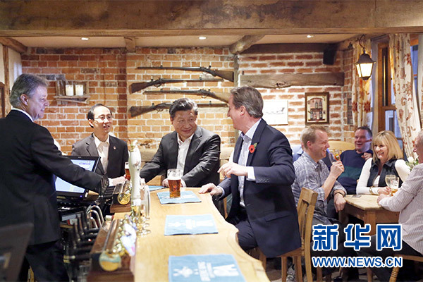 這是會晤結(jié)束后，習(xí)近平在卡梅倫陪同下乘車前往當(dāng)?shù)匦℃?zhèn)體驗酒吧文化。新華社記者 鞠鵬 攝